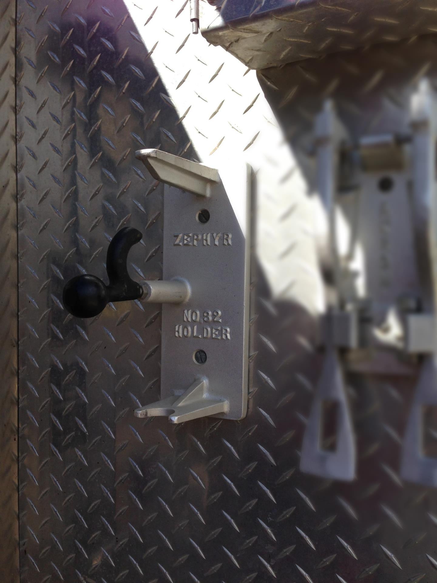 Holder for Span-hammer by Zephyr Industries mounted vertically on truck